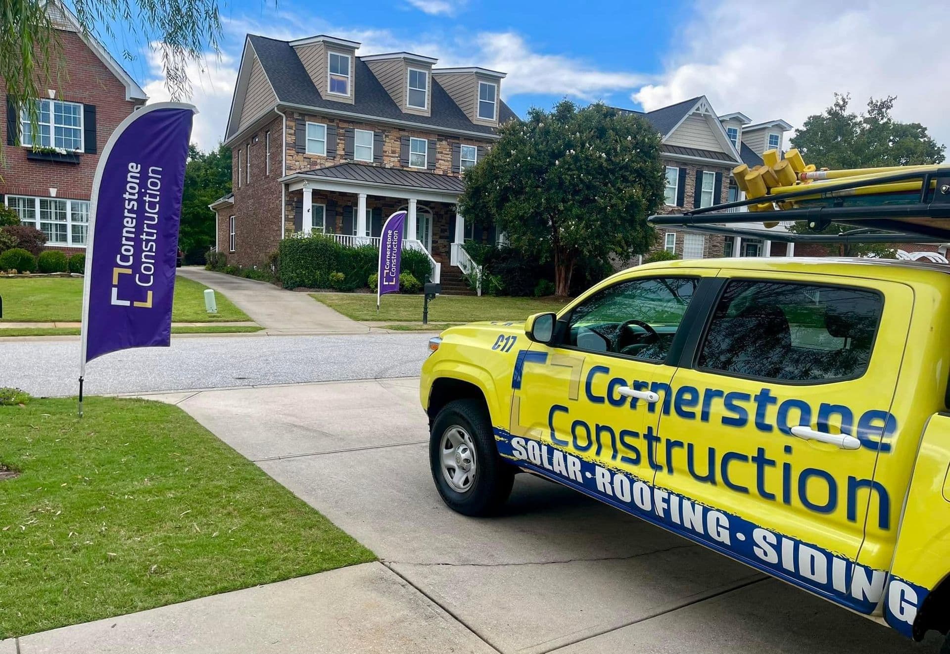 A Cornerstone Construction truck parked in a driveway outside a home.