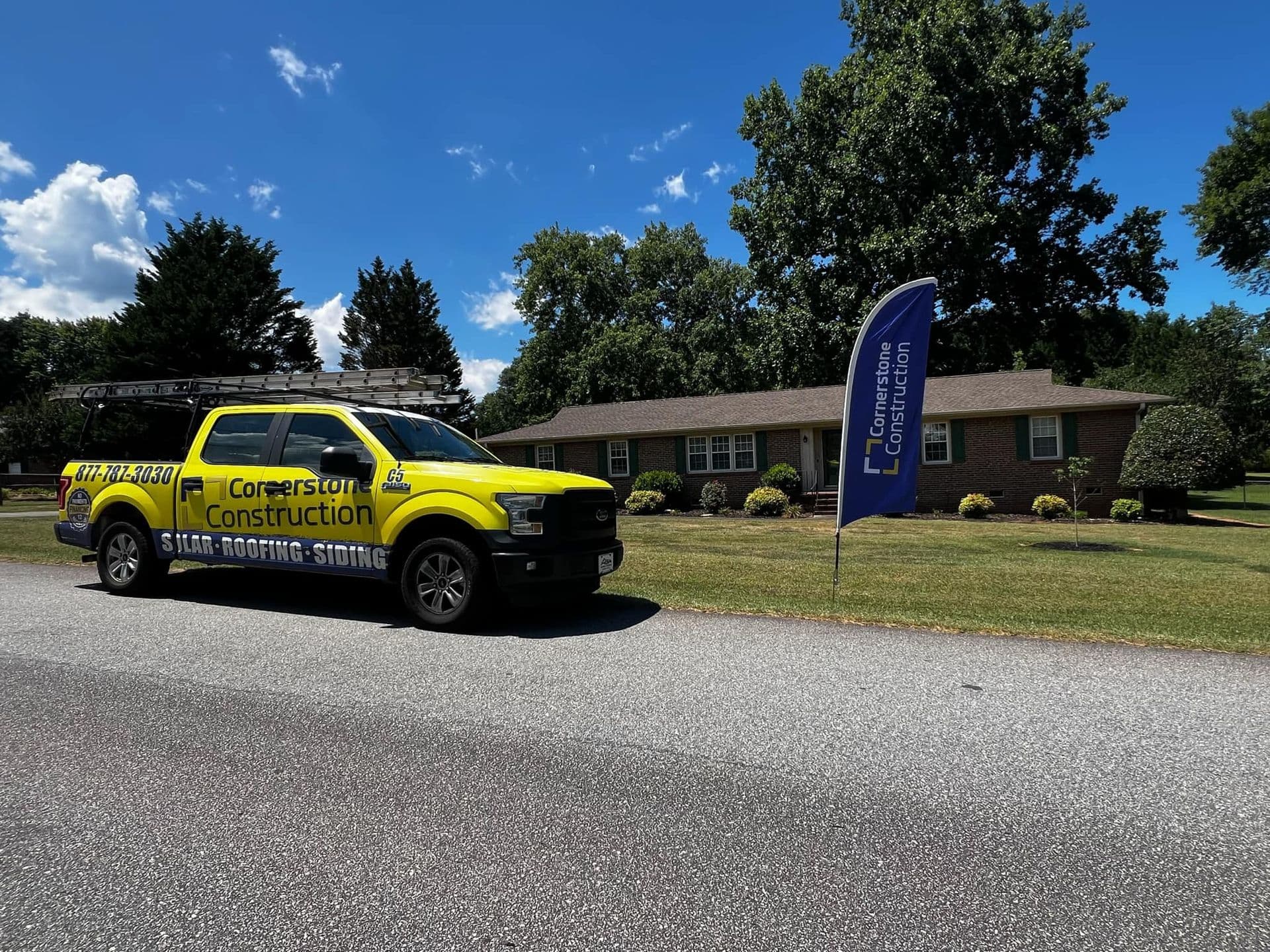 A Cornerstone Construction truck parked in front of a house.