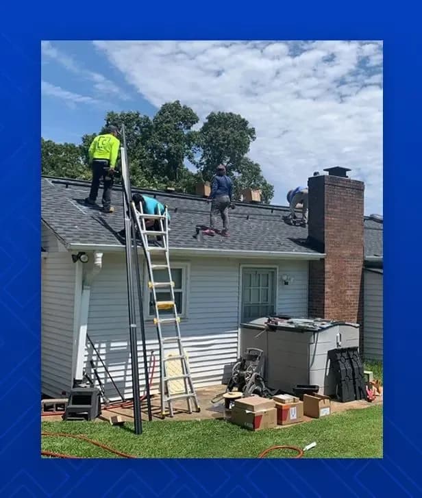 Workers install new asphalt shingle roofing.