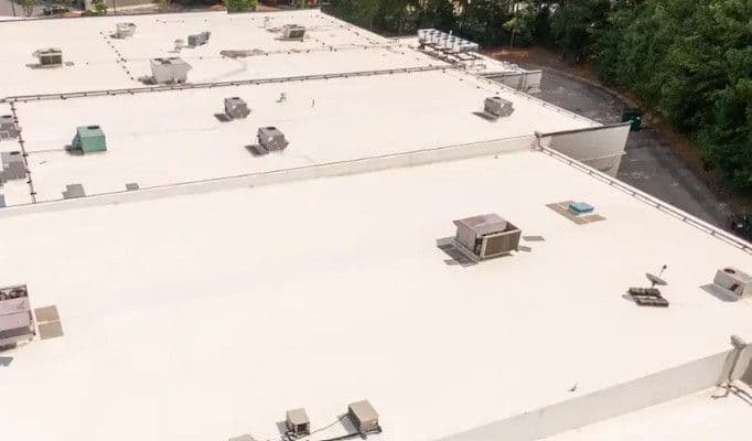 An overhead view of a commercial building with new white roofing.