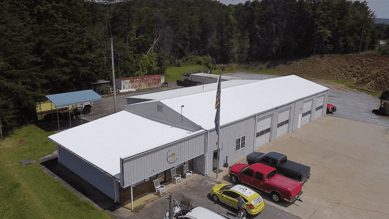 An aerial view of a commercial building with newly-installed white roofing.