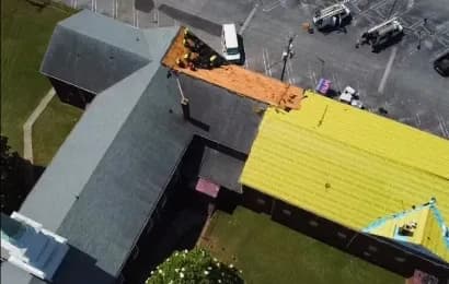 An aerial overhead view of a new roof being installed on a commercial building.
