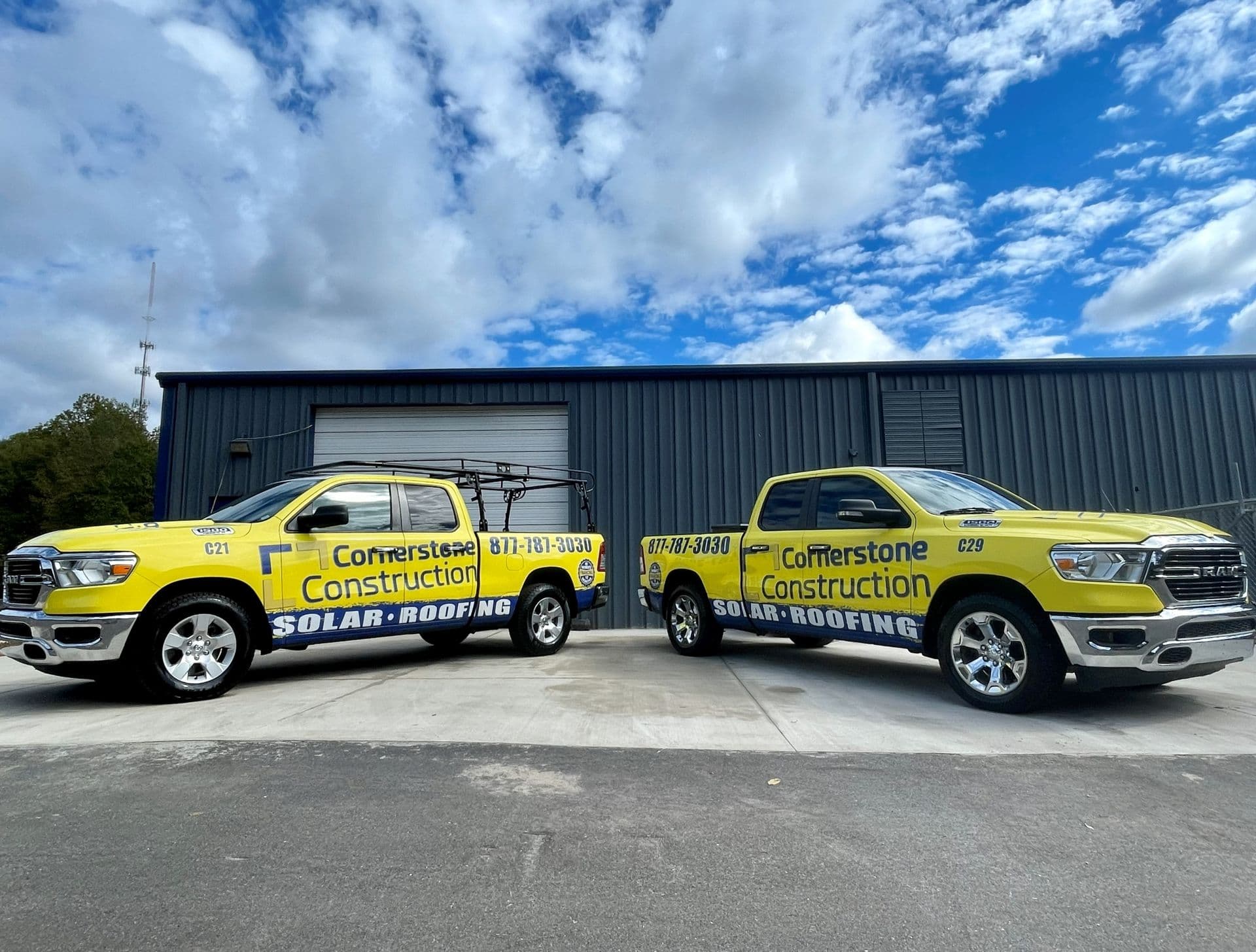 Cornerstone Construction trucks parked in front of a warehouse.