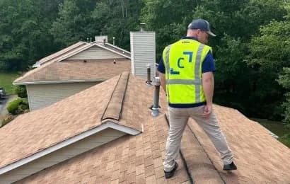 A Cornerstone Construction employee inspects a roof.