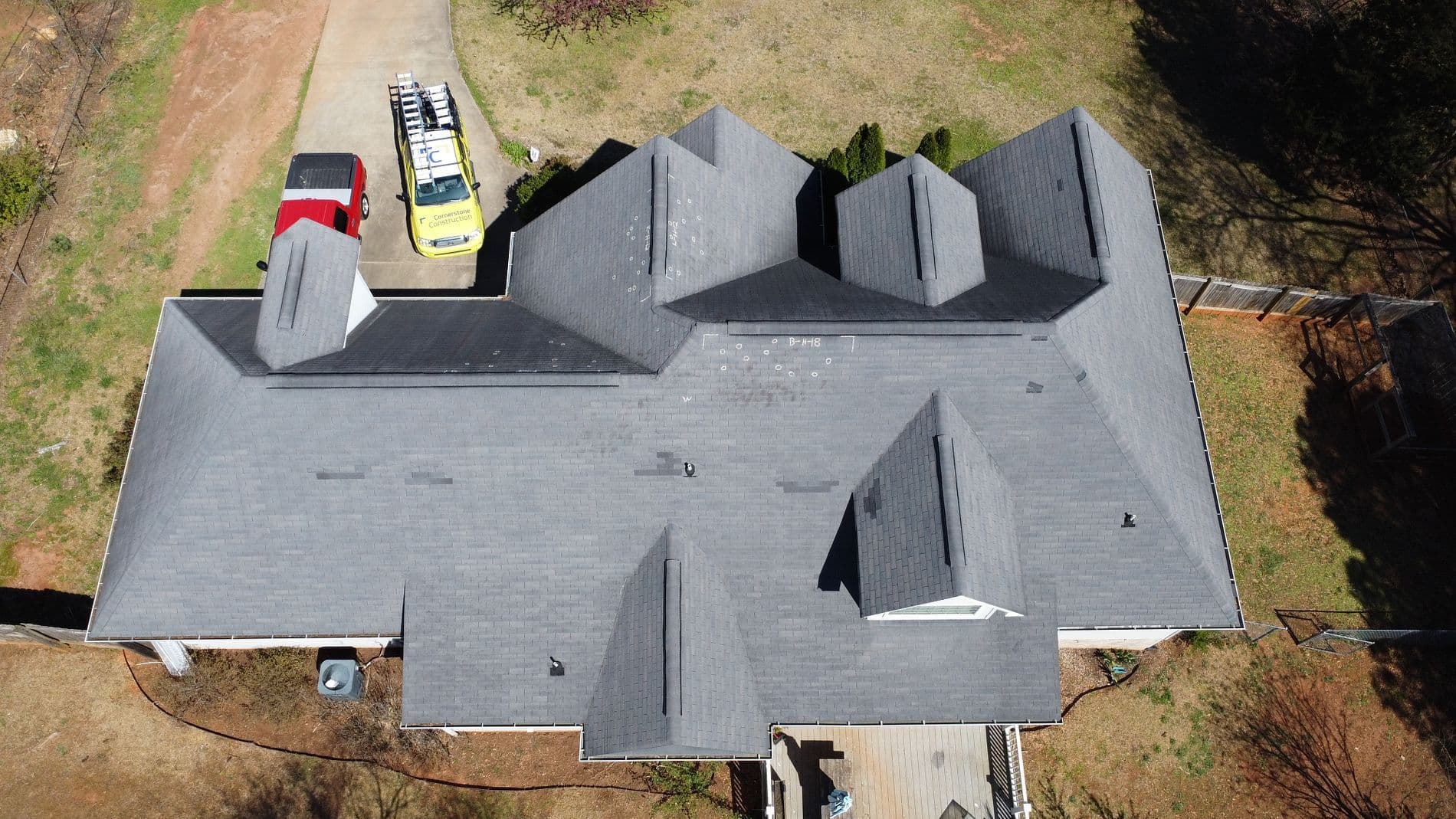 An overhead aerial shot of a house with gray shingle roofing.