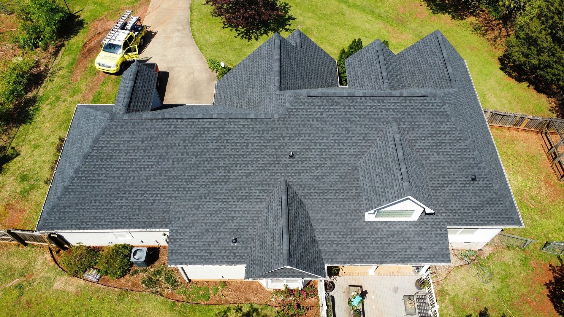 An aerial overhead view of a new gray asphalt shingle roof.