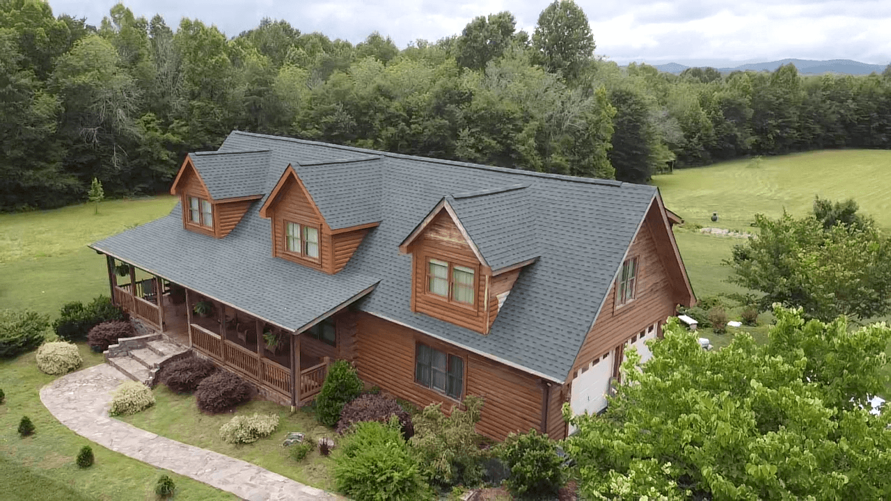 A brown log cabin style house with a new roof installed by Cornerstone Construction.