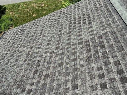 Worn, aging gray asphalt shingle roofing.