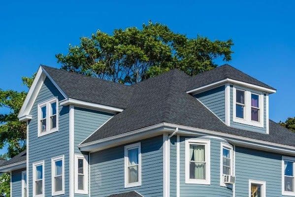 A blue house with white trim and new dark gray asphalt shingle roofing.