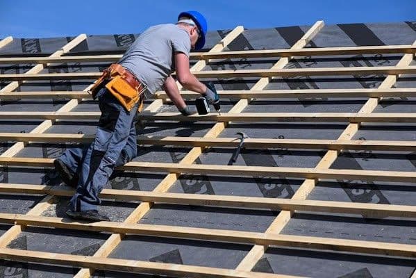 A worker installs roofing.
